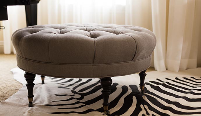 A round, tufted fabric ottoman