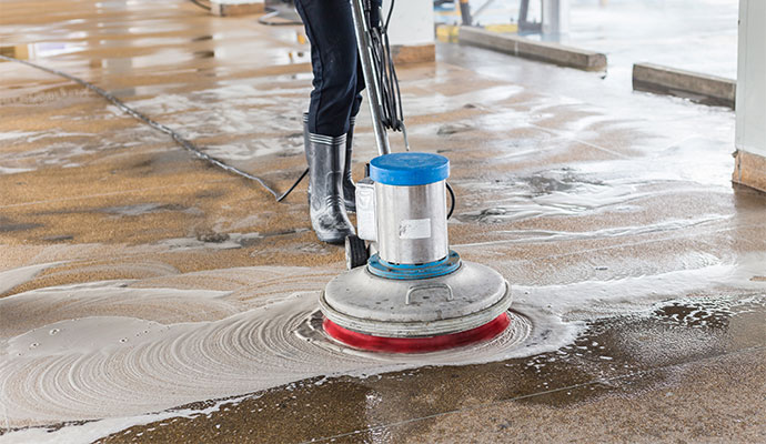 Expert cleaning concrete floor with machine
