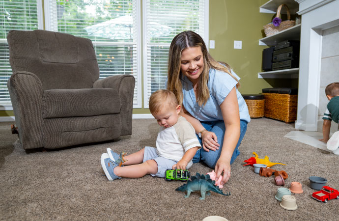 Mom and kid playing on the allerge free carpet