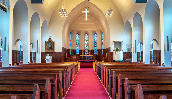 Church sanctuary with wooden pews and red carpet runner