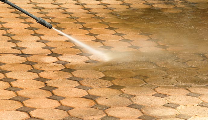 Professional cleaning a concrete floor using a pressure washer