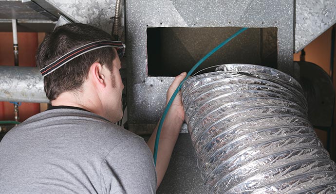 A person is cleaning a duct in commercial area