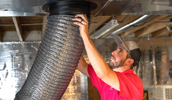 Technician inspecting dryer vent hose connection