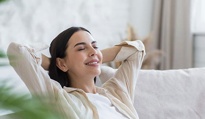 Woman relaxing comfortably on a sofa in a home with clean indoor air