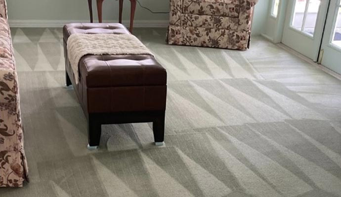 Cleaned carpet in a living room with ottoman and armchairs
