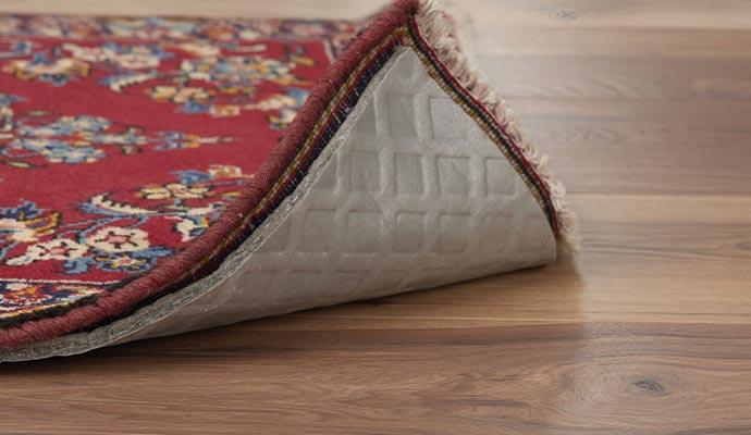 Non-slip rug pad installed under a rug to prevent movement.