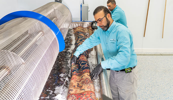 Professionals cleaning a carpet using a large cleaning machine