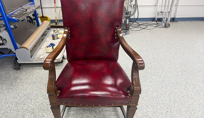 Red leather armchair with wooden arms in a workshop