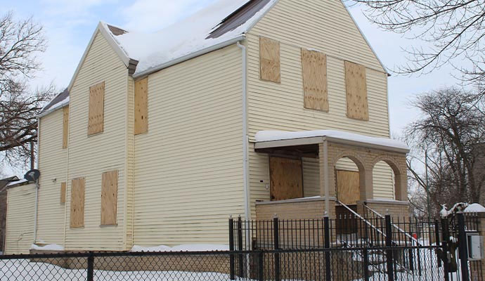 House exterior with plywood covering windows in winter