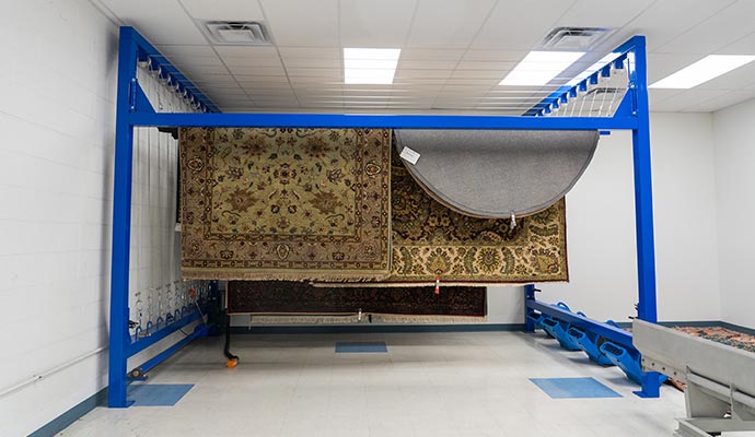 Rugs hanging on industrial rug drying rack