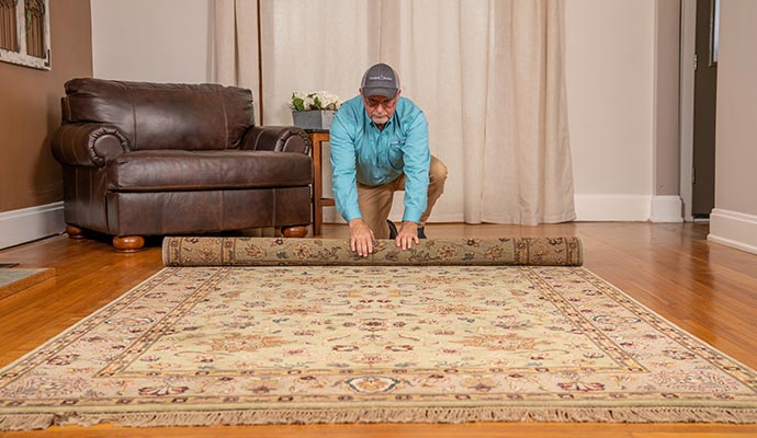A person is folding rug