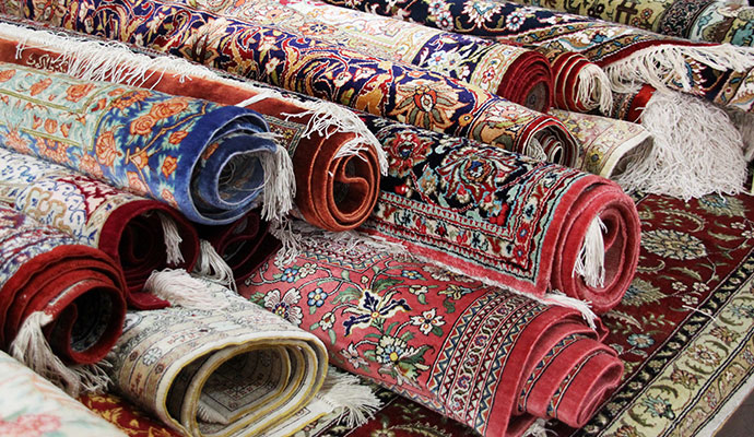 Collection of rolled colorful oriental rugs stacked together for climate-controlled storage service