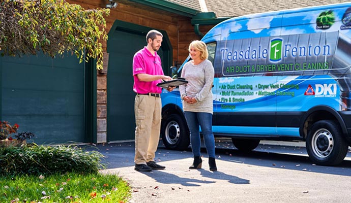 Service provider is discussing with homeowner in front of service vehicle