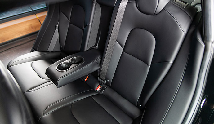 Clean black leather rear car seats with a fold-down center armrest