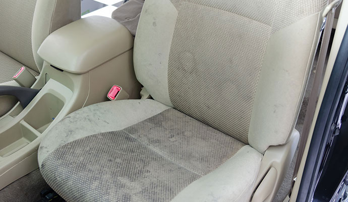 Fabric car seat with visible stains and discoloration