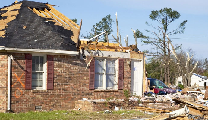 House with severe roof and structural damage after a storm