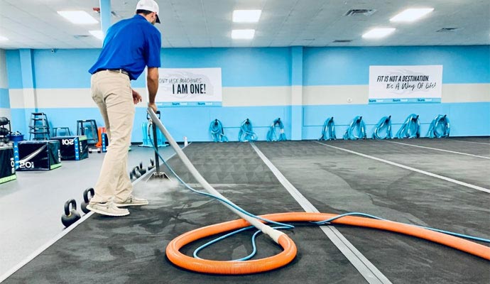 Technician cleaning gym floor mats