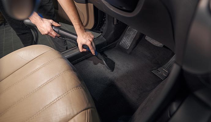 Vacuuming car interior floor